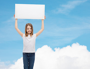 Image showing smiling little girl holding blank white board