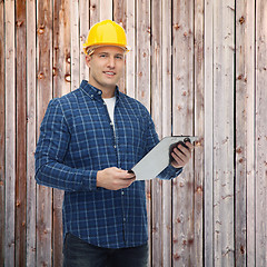 Image showing smiling male builder in helmet with clipboard