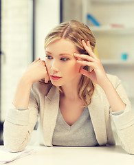 Image showing bored and tired woman behind the table