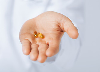 Image showing doctor hands giving capsule and glass of water