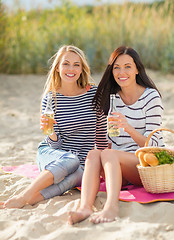 Image showing happy young women drinking beer on beach