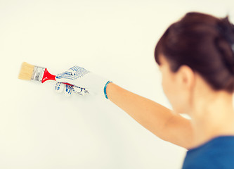 Image showing woman with paintbrush colouring the wall