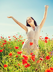 Image showing smiling young woman on poppy field