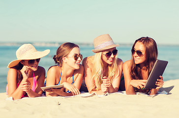 Image showing group of smiling young women with tablets on beach