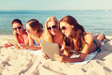 Image showing group of smiling young women with tablets on beach