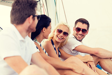 Image showing smiling friends sitting on yacht deck