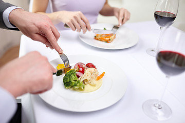 Image showing close up of couple eating appetizers at restaurant