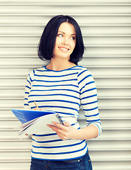 Image showing happy and smiling teenage girl with big notepad