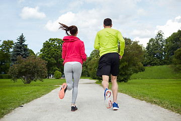 Image showing smiling couple running outdoors