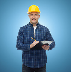 Image showing smiling male builder in helmet with clipboard