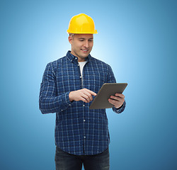 Image showing smiling male builder in helmet with tablet pc