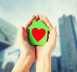 Image showing hands holding green paper house