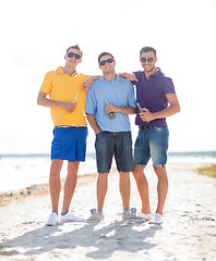 Image showing happy friends drinking beer and walking on beach