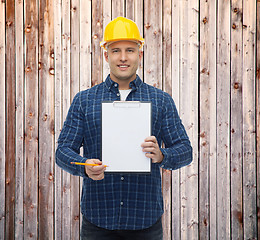 Image showing smiling male builder in helmet with clipboard