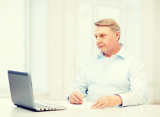 Image showing old man filling a form at home