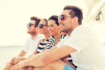 Image showing smiling friends sitting on yacht deck