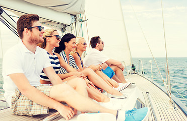 Image showing smiling friends sitting on yacht deck