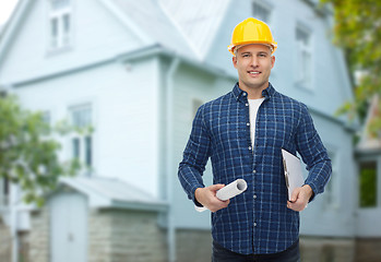 Image showing smiling male builder in helmet with blueprint