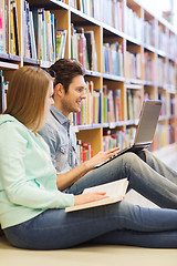 Image showing happy students with laptop in library