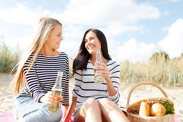 Image showing happy young women drinking beer on beach