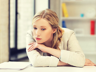 Image showing bored and tired woman behind the table