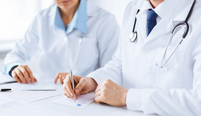 Image showing doctor and nurse writing prescription paper