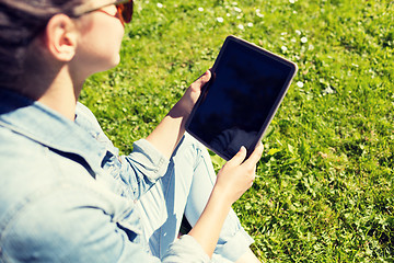 Image showing close up of girl with tablet pc sitting on grass