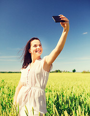 Image showing smiling girl with smartphone on cereal field
