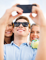 Image showing group of friends taking selfie with cell phone