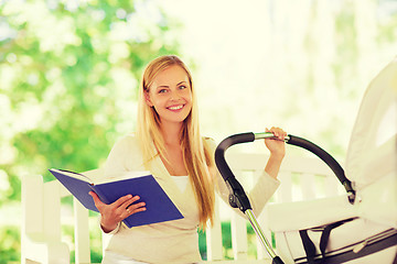 Image showing happy mother with book and stroller in park