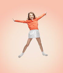 Image showing happy girl in casual clothes jumping high