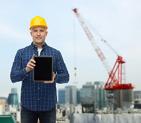 Image showing smiling male builder in helmet with tablet pc