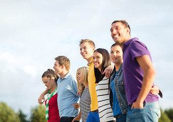 Image showing group of happy friends walking along beach