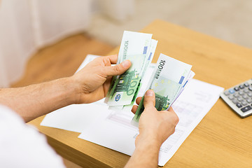 Image showing close up of man hands counting money at home