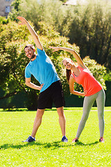 Image showing smiling couple stretching outdoors