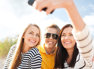 Image showing group of friends taking selfie with cell phone