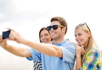 Image showing group of friends taking selfie with cell phone