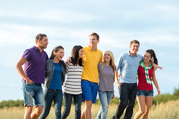 Image showing group of happy friends walking along beach