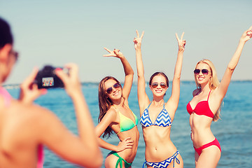 Image showing group of smiling women photographing on beach