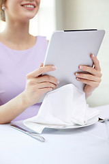 Image showing close up of woman with tablet pc at resturant