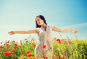 Image showing smiling young woman on poppy field