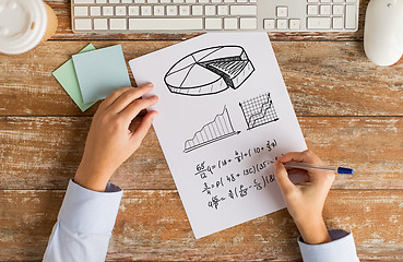 Image showing close up of hands solving task or writing equation