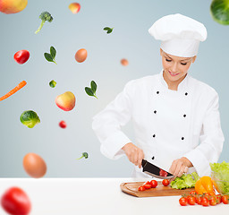 Image showing smiling female chef chopping vegetables