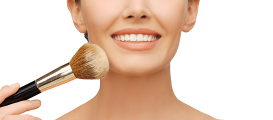 Image showing woman applying powder foundation with brush