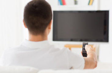 Image showing man watching tv and changing channels at home