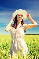 Image showing smiling young woman in straw hat on cereal field