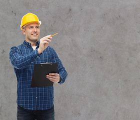 Image showing smiling male builder in helmet with clipboard