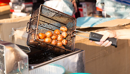 Image showing close up of cook frying meatballs at street market