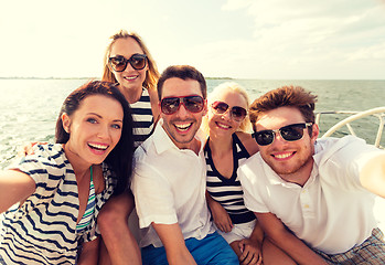 Image showing smiling friends sitting on yacht deck