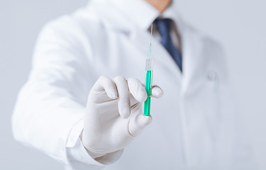 Image showing male doctor holding syringe with injection